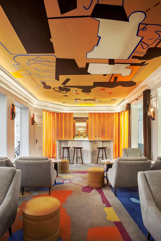 Bar dont le sol et le plafond sont traités comme des oeuvres d'art colorées